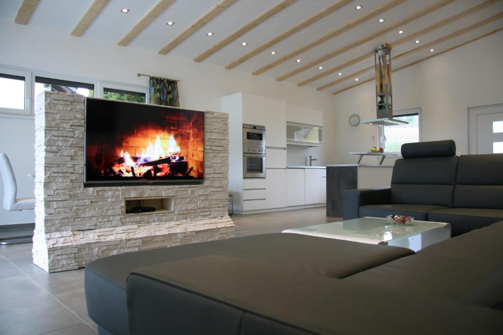 a living room with a fireplace and a tv at Urlaubsapartment am Silbersee in Villach