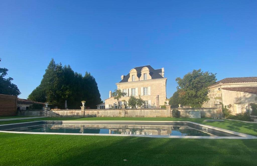 的住宿－Le Grand Berger Chambres D'Hotes，一座大房子,在庭院里设有一个游泳池