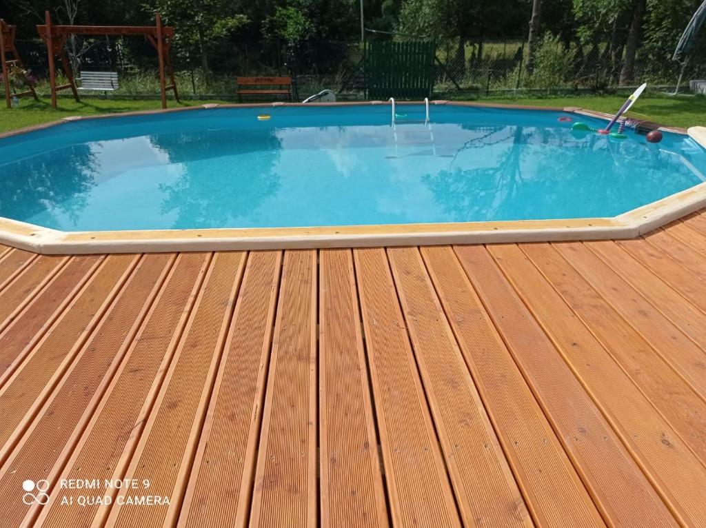 a swimming pool on a deck with a wooden floor at Czesławka in Zawoja