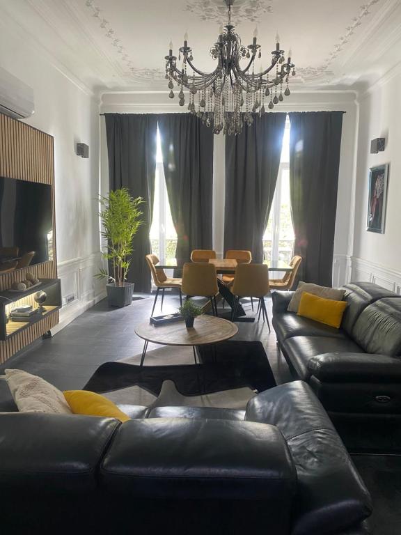 a living room with a couch and a chandelier at Pyramide in Mulhouse