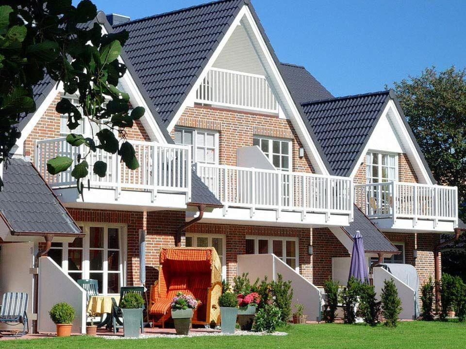 a large brick house with white balconies on it at DUeNENHOF-4 in Olsdorf