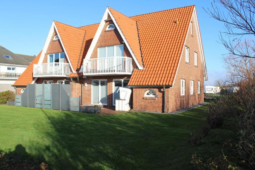 a brick house with an orange roof at Utholmer-Strasse-3 in Brösum