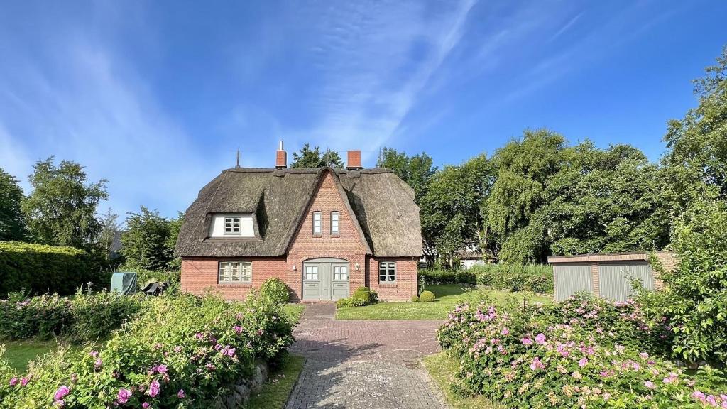 a large brick house with a thatched roof at Reetdachhaushaelfte-1 in Sankt Peter-Ording