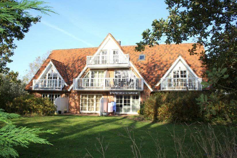 a large brick house with white windows and a roof at Landhaus-am-Golfplatz-9 in Sankt Peter-Ording