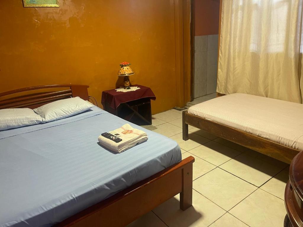 a bedroom with two beds and a table with a lamp at Funky Monkey in Guayaquil