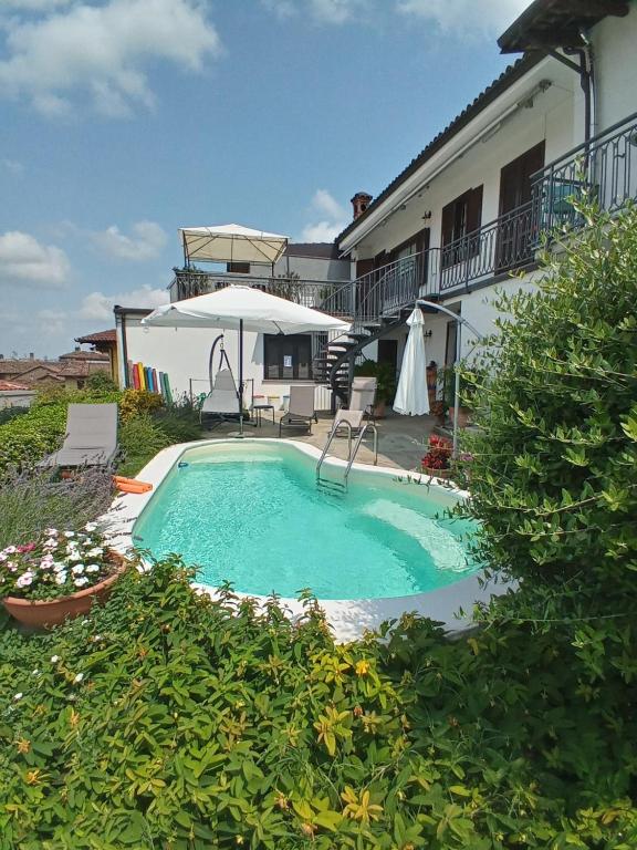a swimming pool in front of a house at A Vijeta in Castiglione Falletto