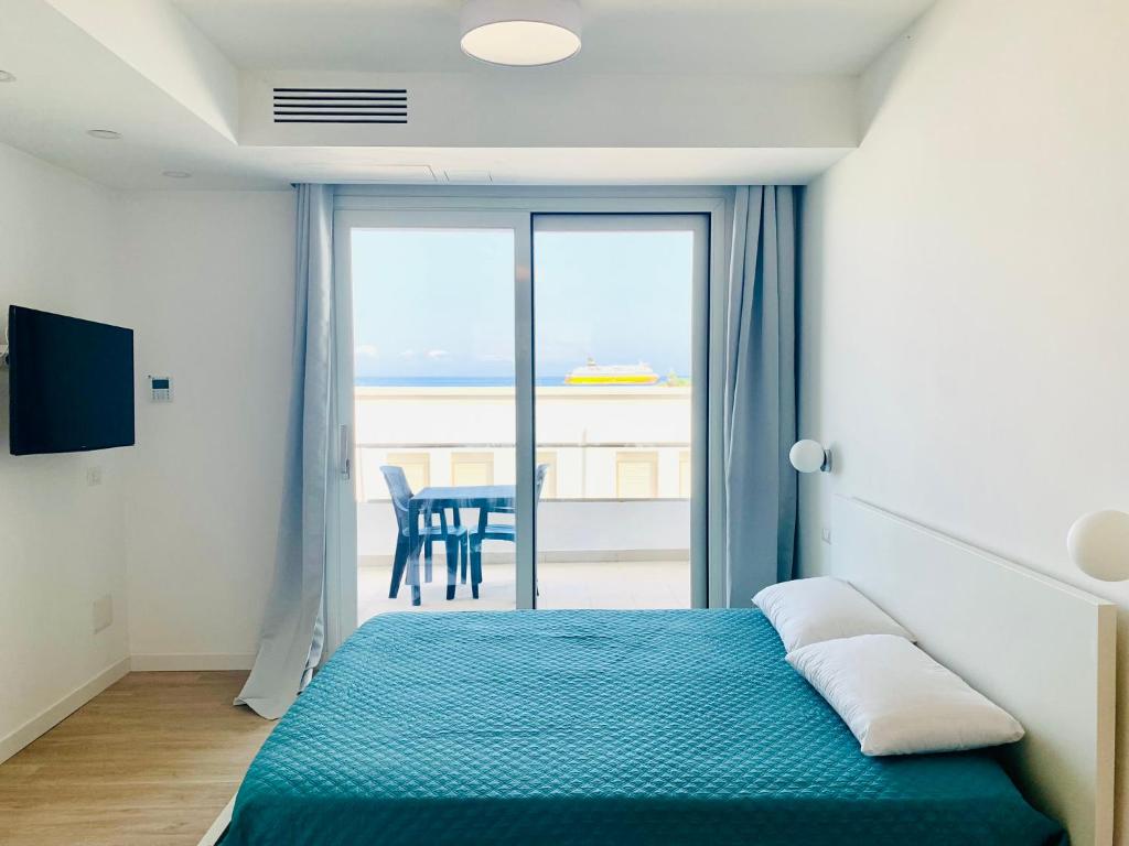 a bedroom with a bed and a table with a view at Le Conchiglie Residence in Porto Torres