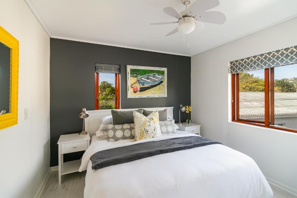 a bedroom with a white bed and a ceiling fan at Founders Keepers - Leisure Isle in Knysna