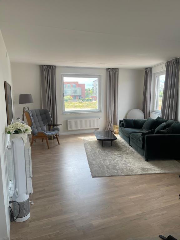 a living room with a black couch and a window at New 4 bedroom apartment in Malmö in Malmö