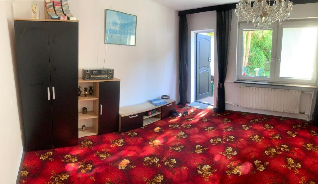 a living room with a red carpet and a large room at Domek nad morzem in Sopot