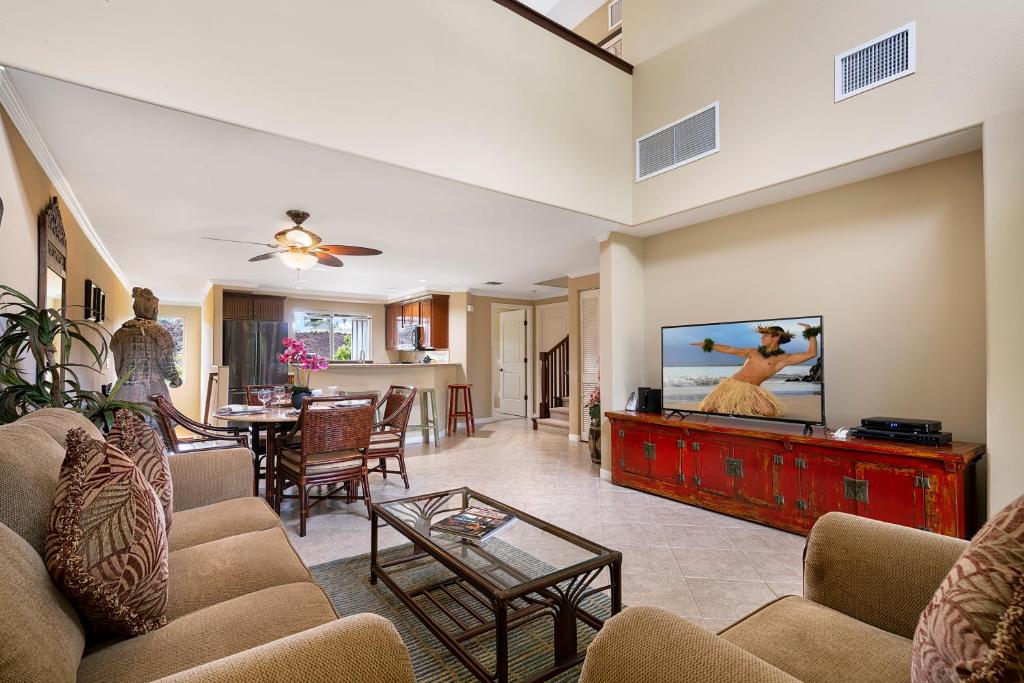 a living room with a flat screen tv on a wall at Palm Villas at Mauna Lani I23 in Waikoloa