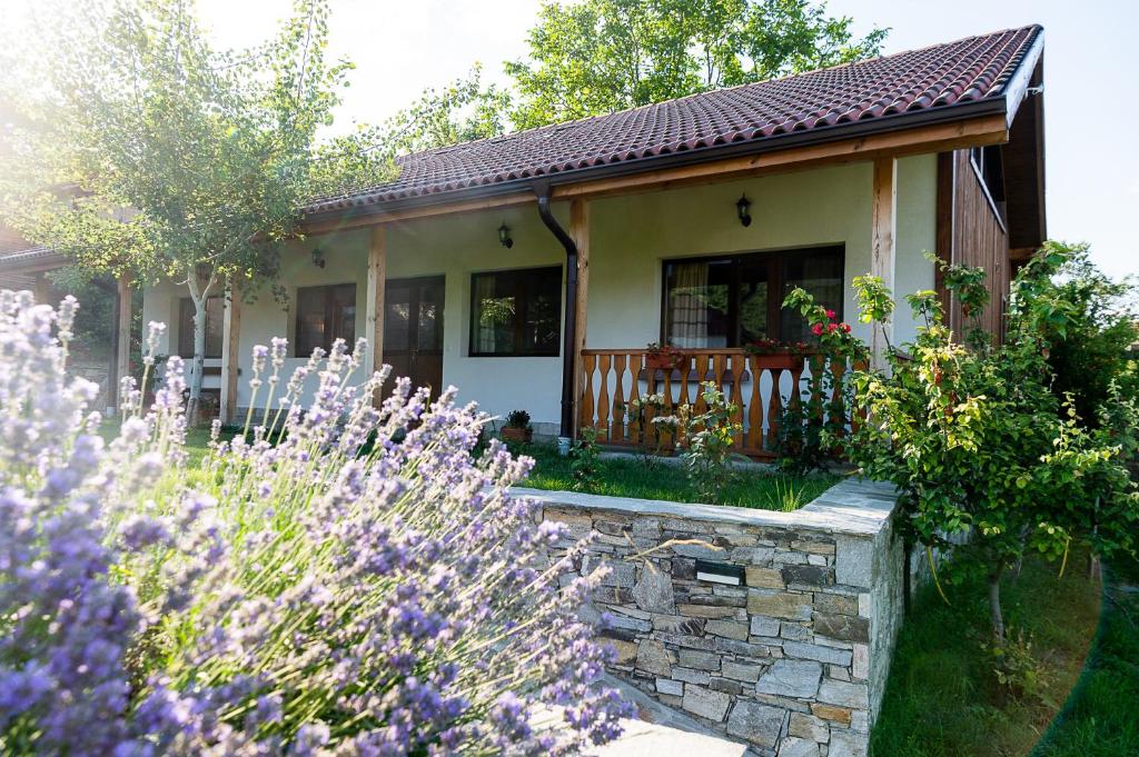una piccola casa con giardino e fiori viola di Walnut Cottage 1 a Deredzhik-Kʼoy