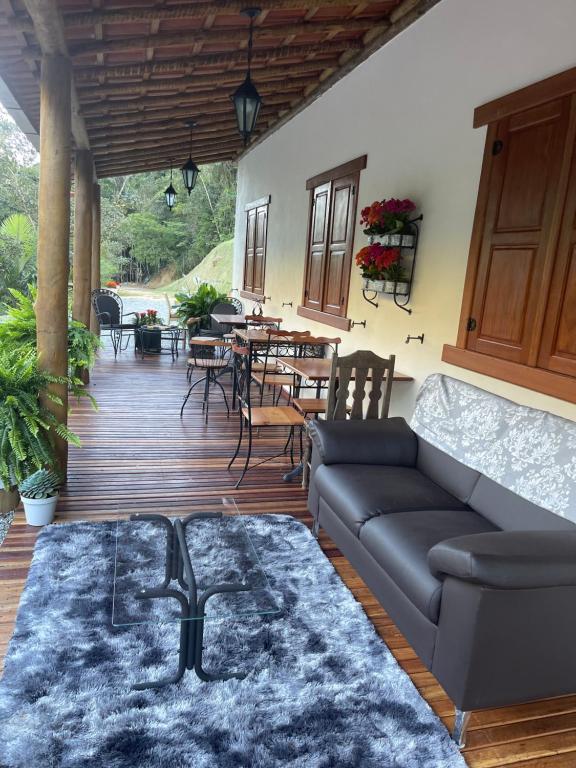 un soggiorno con divano e tavolo di Pousada Sítio das Pedras a Domingos Martins
