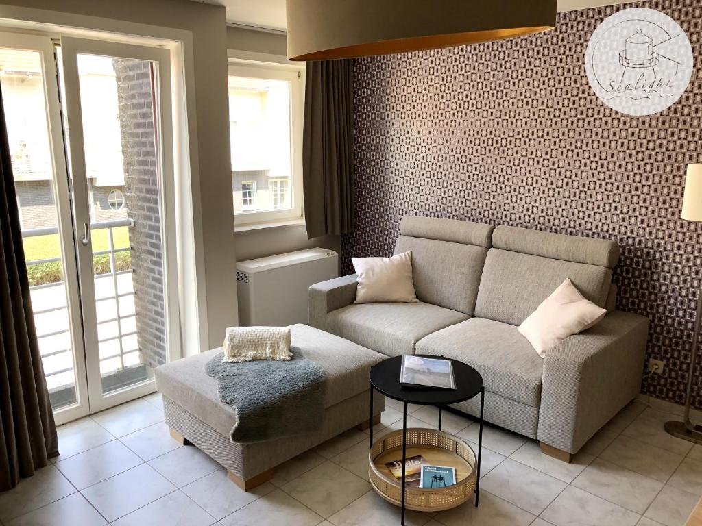 sala de estar con sofá y mesa en Appartement Sealight en De Haan