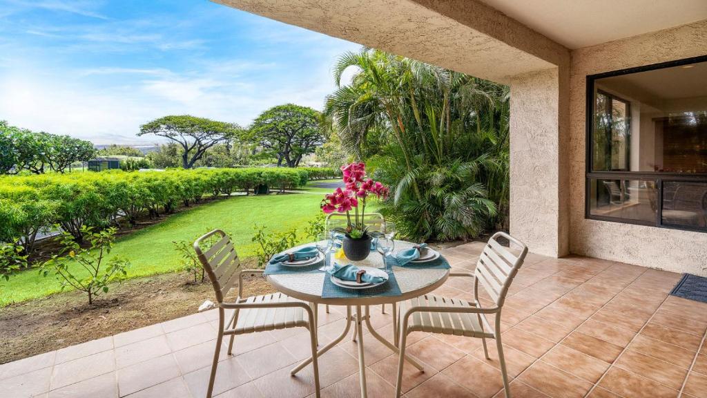 a table and chairs on a patio with a view at The Shores at Waikoloa 117 in Waikoloa