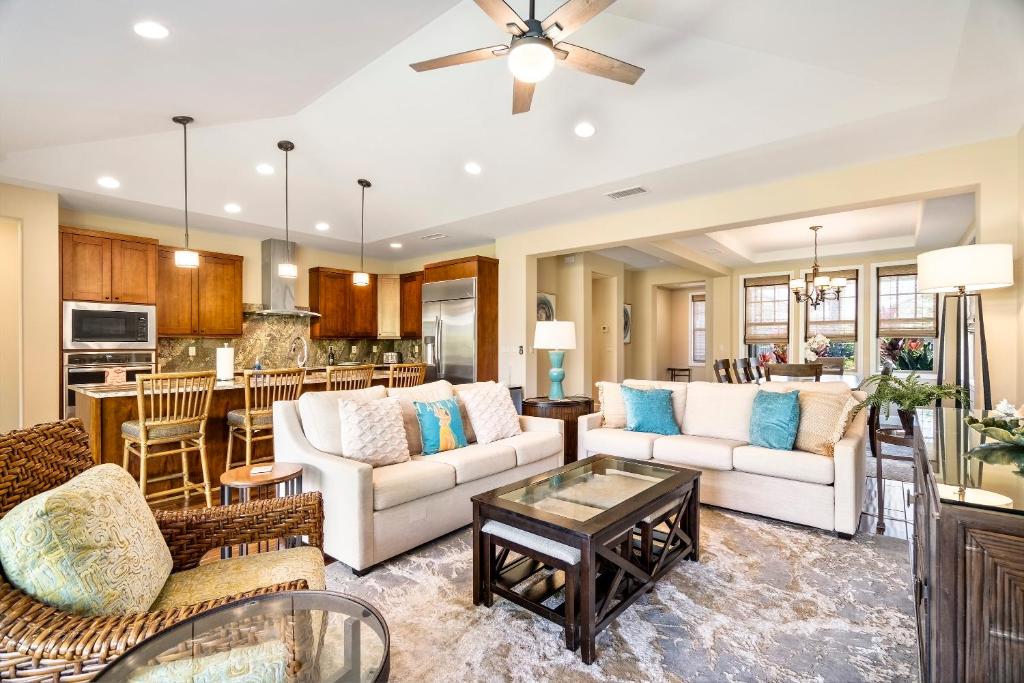 a living room with two couches and a table at Holua Kai 37 in Kailua-Kona