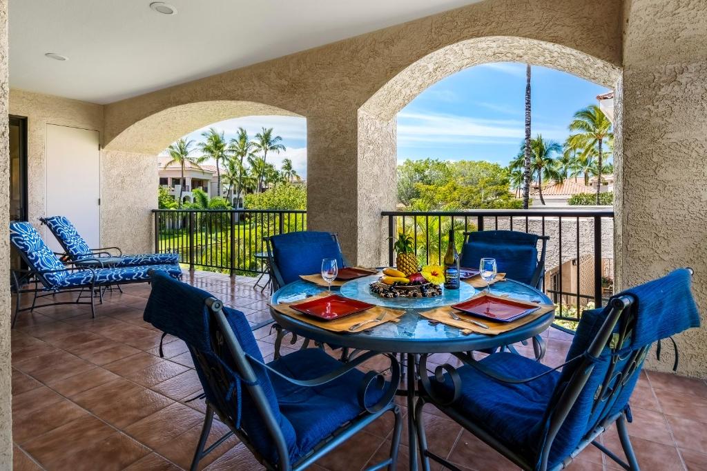 a patio with a table and chairs on a balcony at The Shores at Waikoloa 202 in Waikoloa