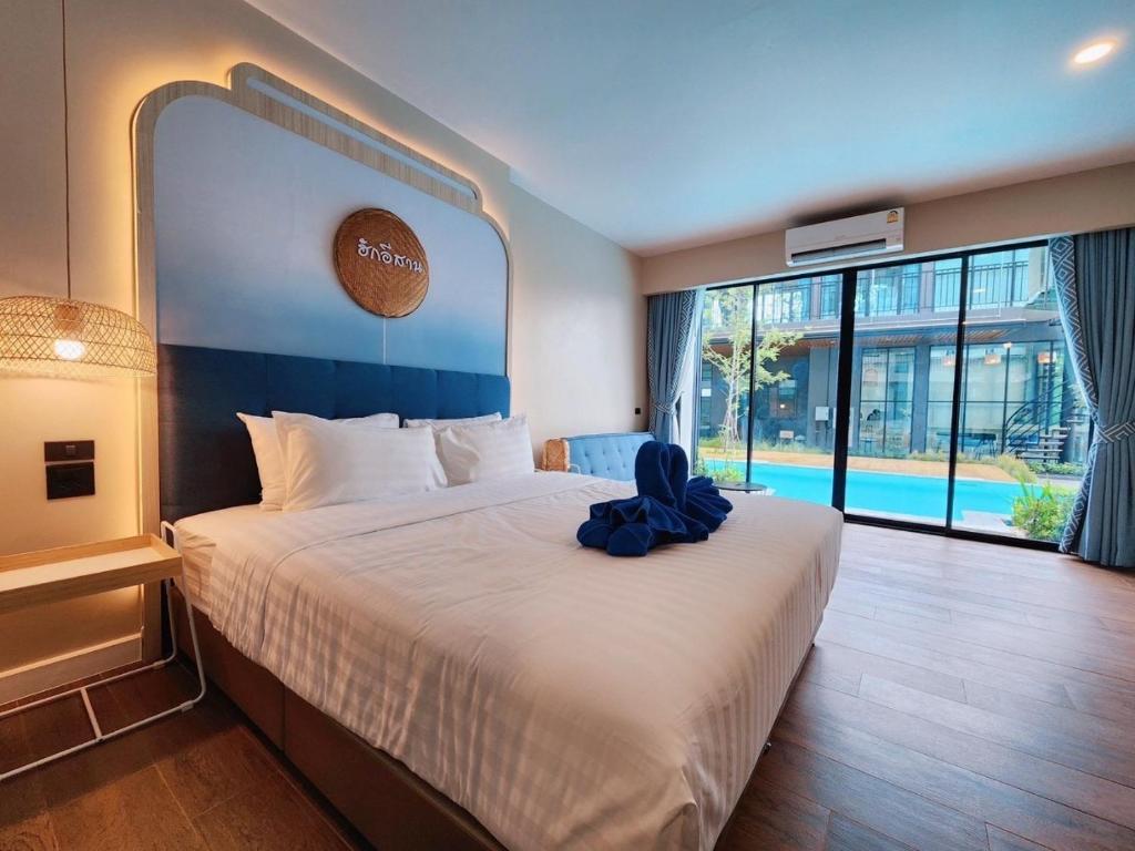 Ban Phang Khwang Tai的住宿－Phu sakon ville hotel，一间卧室配有一张大床,上面有蓝色的弓