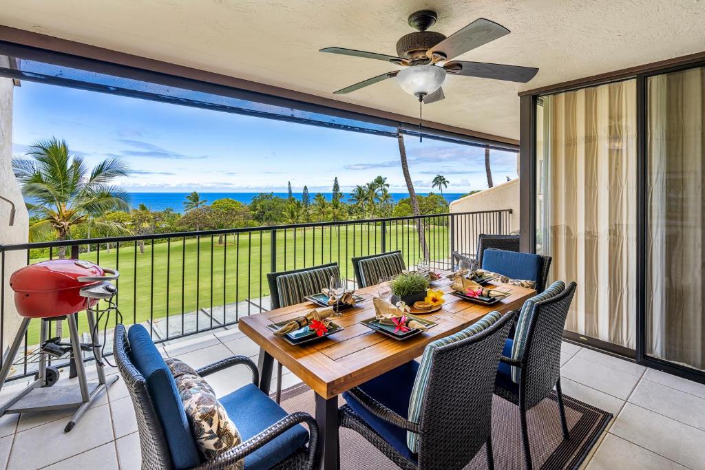 a table and chairs on a balcony with a view of the ocean at Country Club Villas 311 in Kailua-Kona