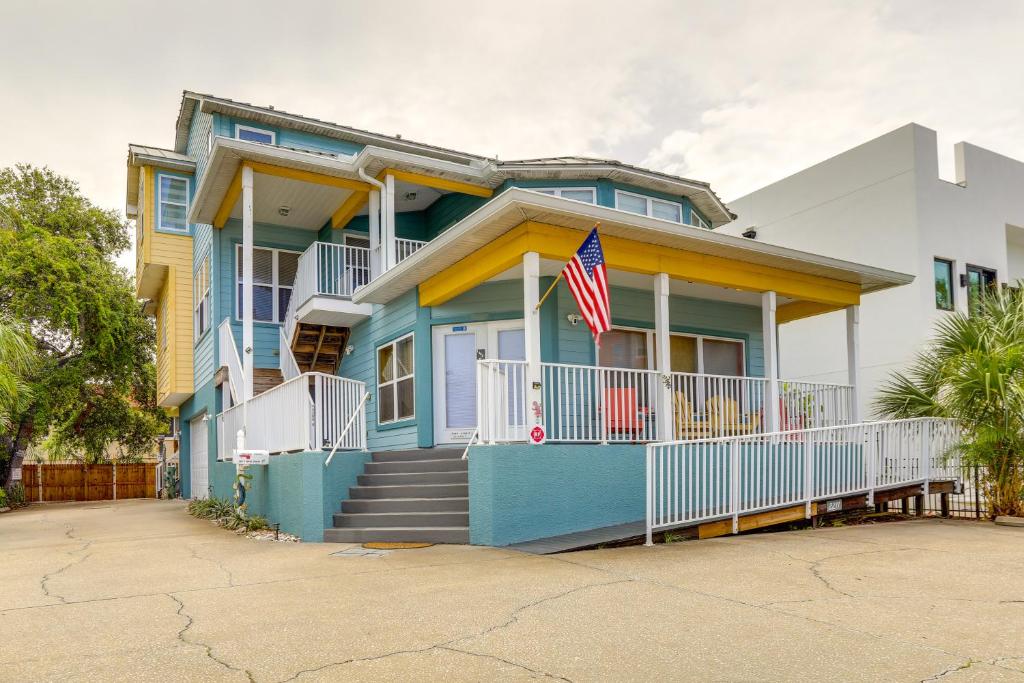 a blue house with an american flag in front of it at Vibrant Condo - Walk to Indian Rocks Beach! in Clearwater Beach