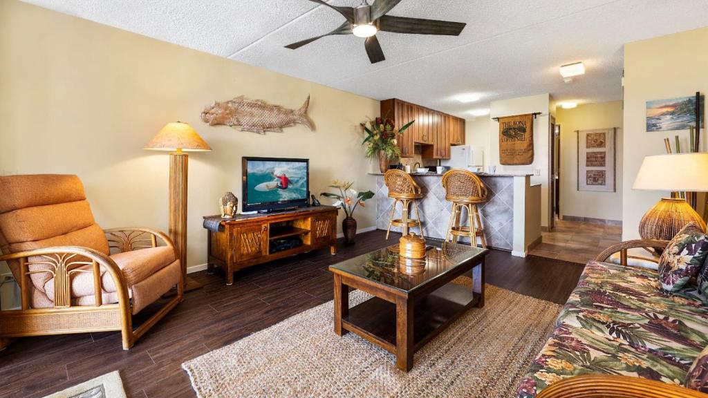 a living room with a couch and a tv at Kona Pacific C520 in Kailua-Kona