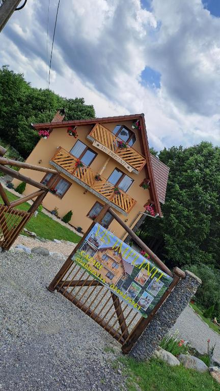 a small house with a balcony on the side of it at Vis Împlinit in Cîrţişoara