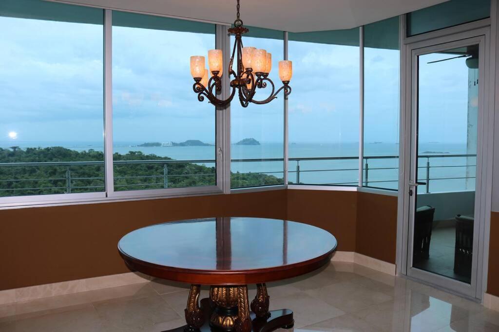 comedor con mesa y ventanas grandes en 21P Penthouse 2 balconies Oceanview Panama, en ArraijÃ¡n