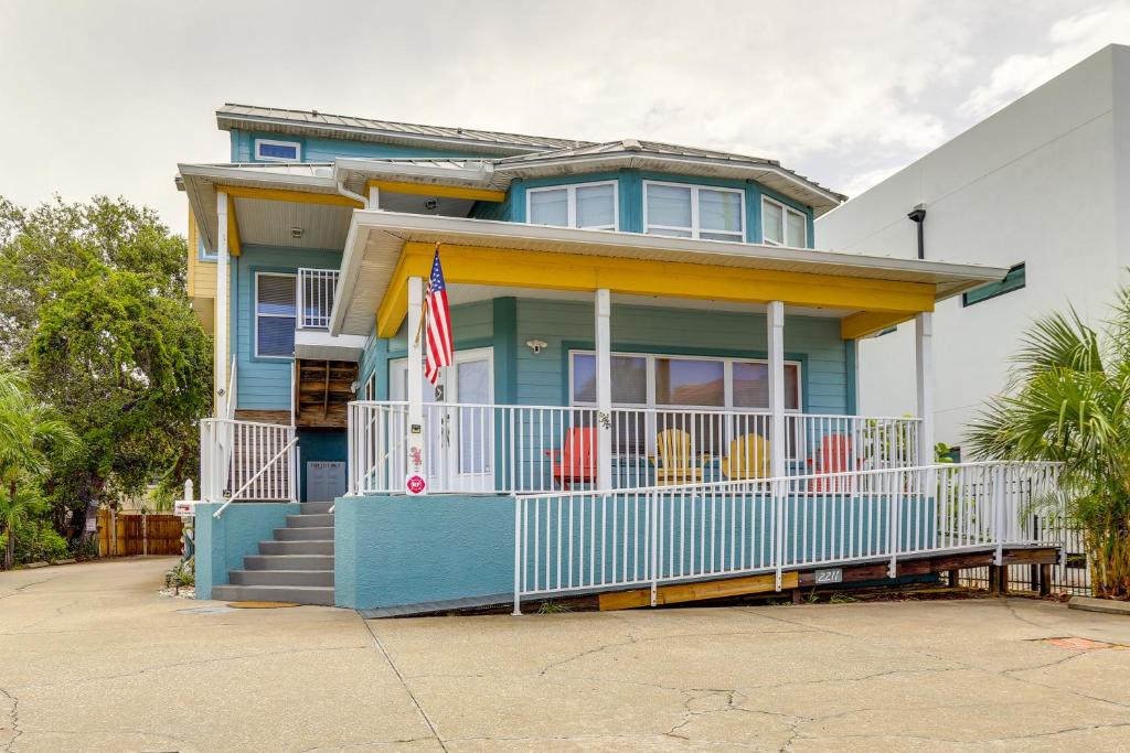 Indian Rocks Vacation Rental Condo Steps to Beach في كليرووتر بيتش: منزل أزرق مع علم على الشرفة الأمامية
