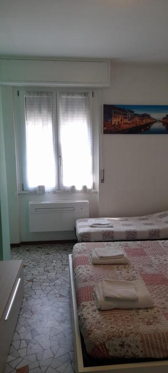 una camera con due letti e due finestre di Edolo Apartment a Milano