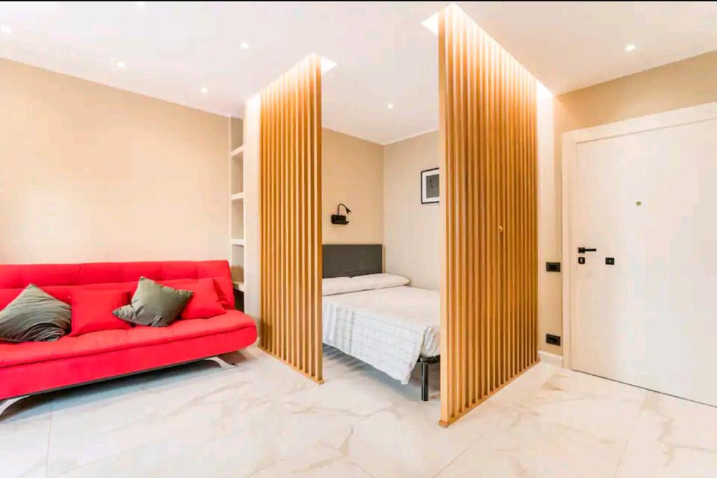 a red couch in a room with a bed and a mirror at Civico 2Cento - Vatican Suite in Rome