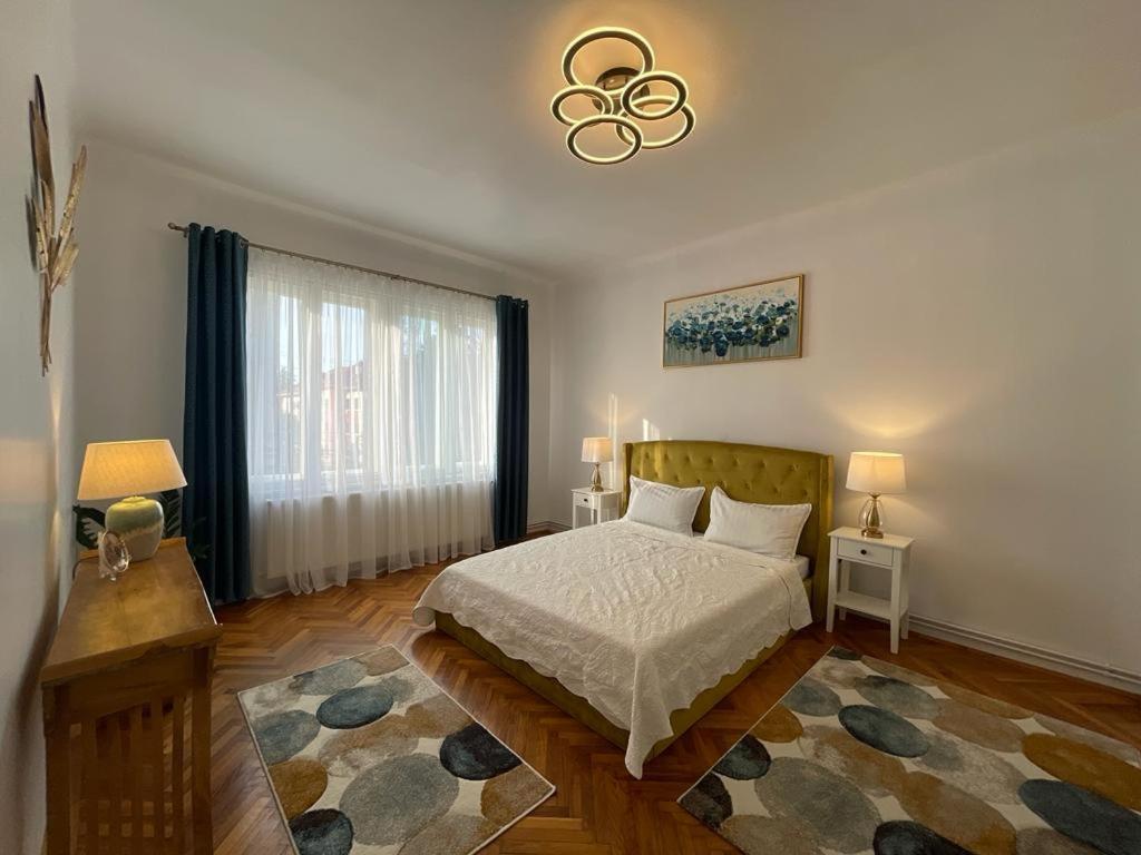 a bedroom with a bed and a chandelier at CityViews Apartment Cluj in Cluj-Napoca