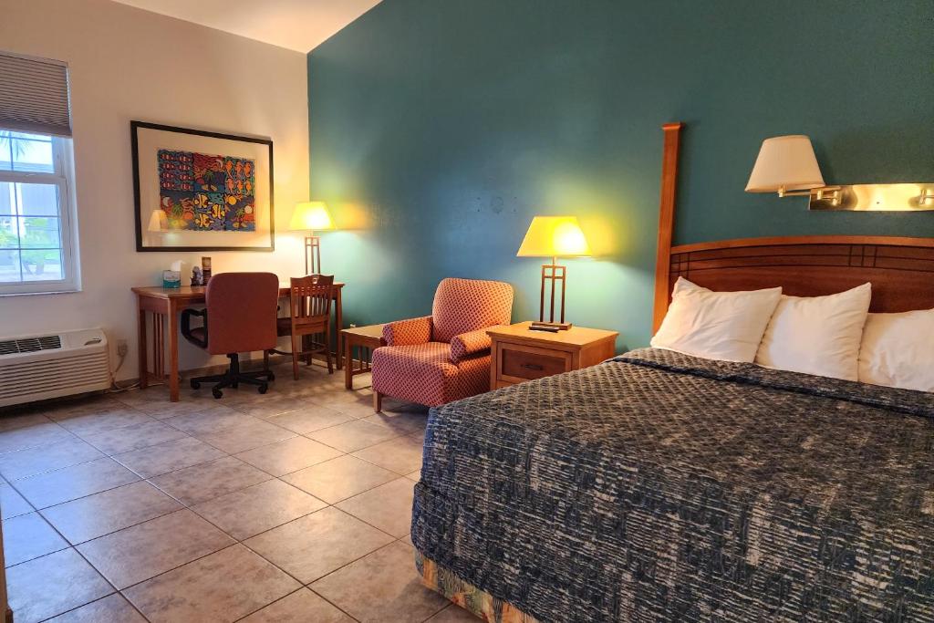 Pokój hotelowy z łóżkiem, krzesłem i biurkiem w obiekcie Ivey House Everglades Adventures Hotel w mieście Everglades City