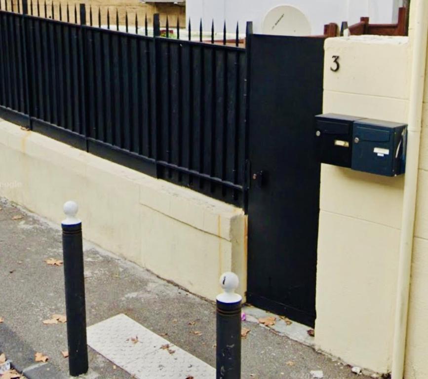 a black fence with a mailbox next to a building at jolie maison individuelle 50 m2 ,design et climatisée, tout confort, wifi, terasse privée , 5 min plage et autoroute, stationnement gratuit in Marseille
