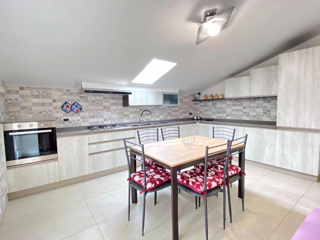 una cucina con tavolo e sedie in legno di Le mimose ad Alba Adriatica