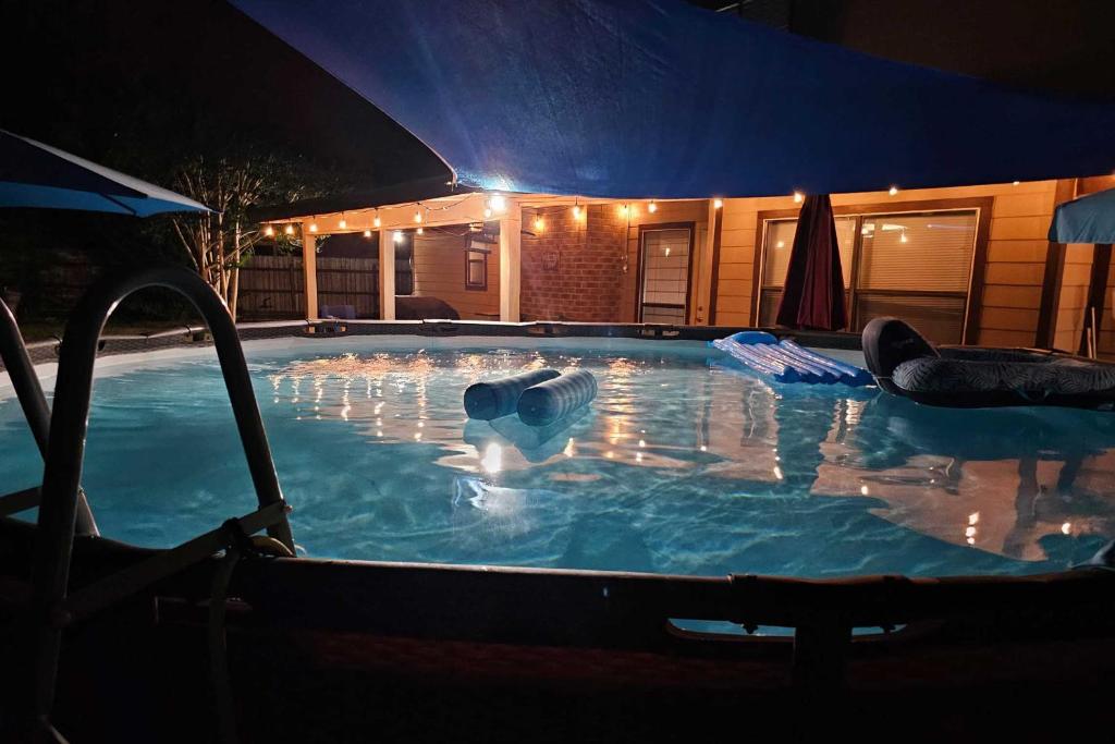 a large swimming pool at a hotel at night at Family-Friendly San Antonio Getaway with Fire Pit! in San Antonio