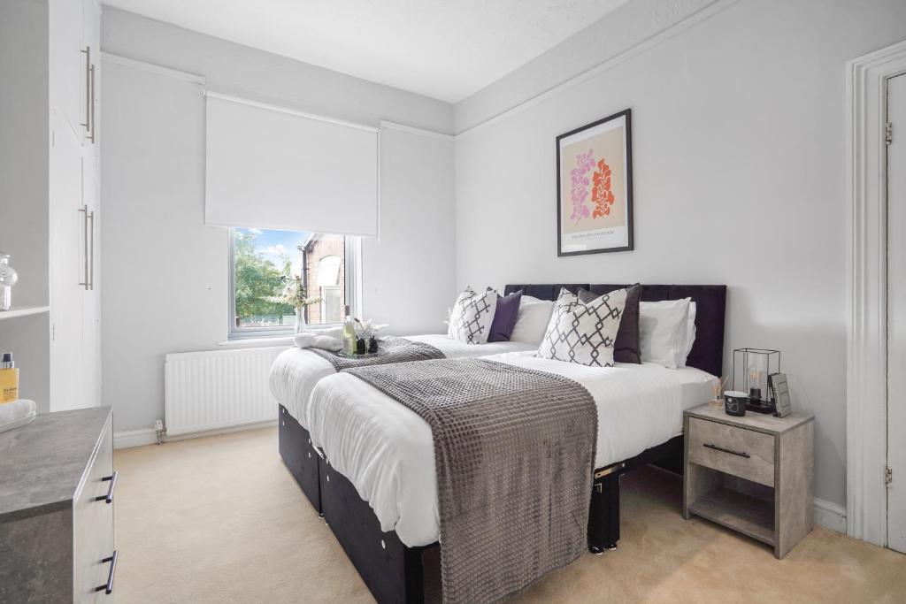 a bedroom with a large bed and a window at The Yorkshire Hosts - Central Castleford 4 Bed House - Free Parking in Castleford