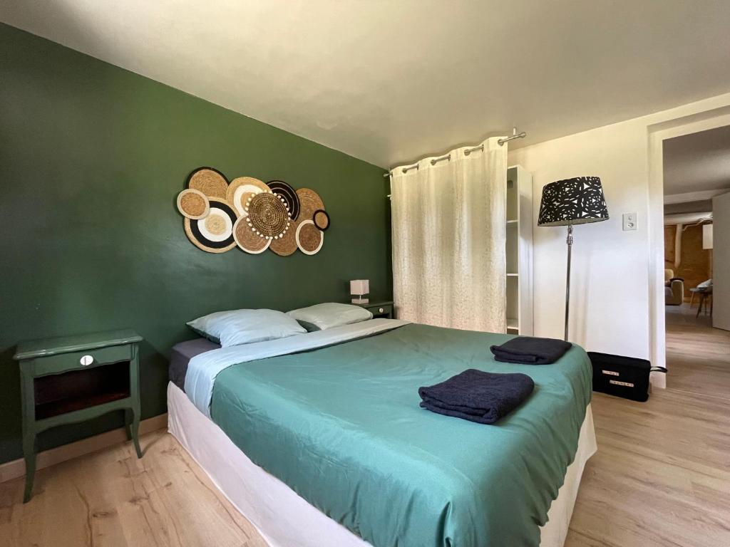 una camera con letto e parete verde di La Gaviota - gîte familial Le Bugue a Le Bugue