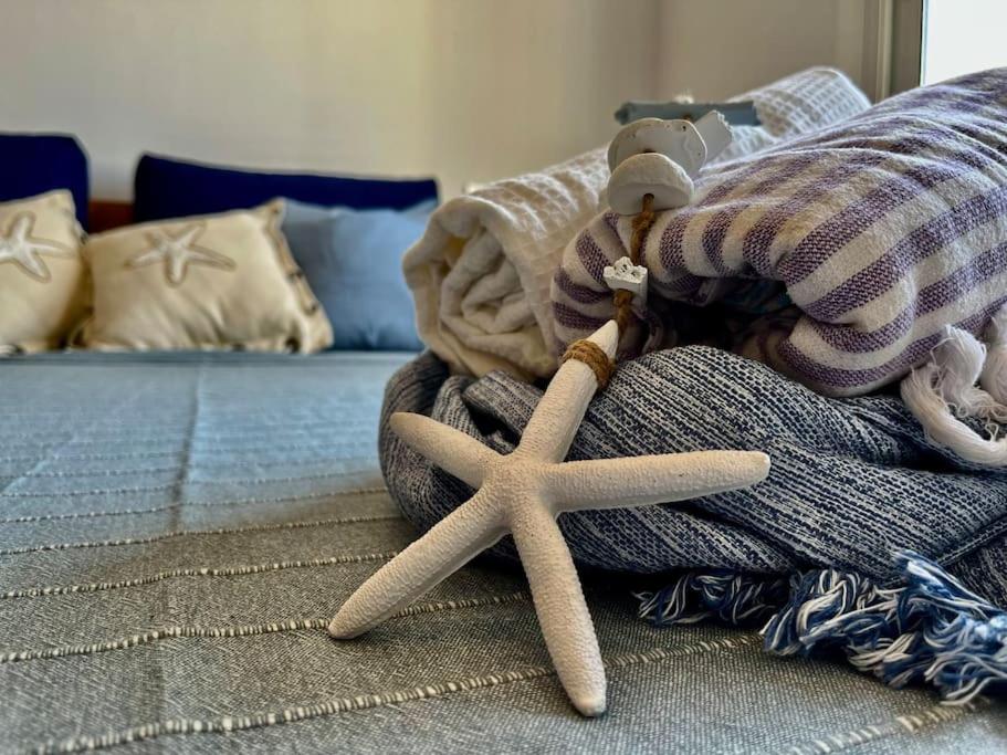 uma estrela-do-mar empalhada sentada à beira de uma cama em Apartamento “La Caleta” em Calella