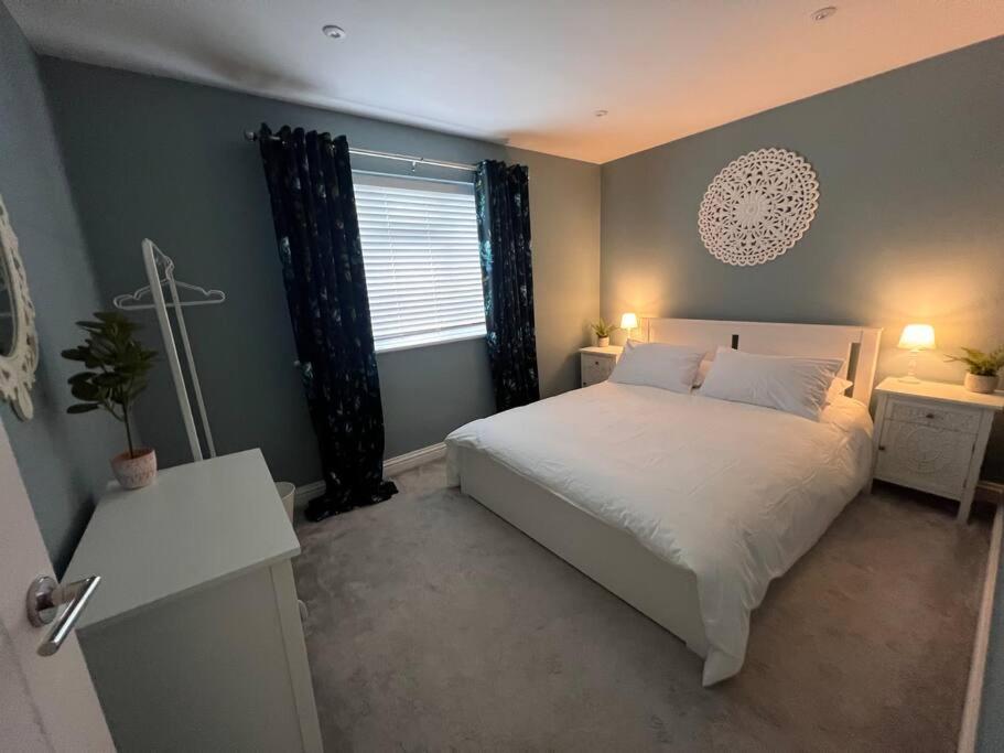 a bedroom with a white bed and a window at Rachelle's Place in Kent