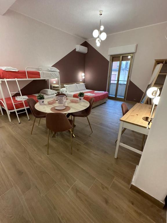 Habitación con literas, mesa y sillas. en B&B Elegance en Villa San Giovanni