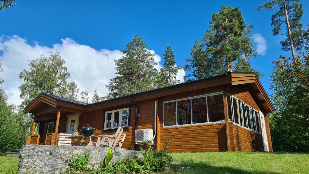 Cabaña de madera en el bosque con ventana grande en Fin stuga nära sjö en Bollnäs