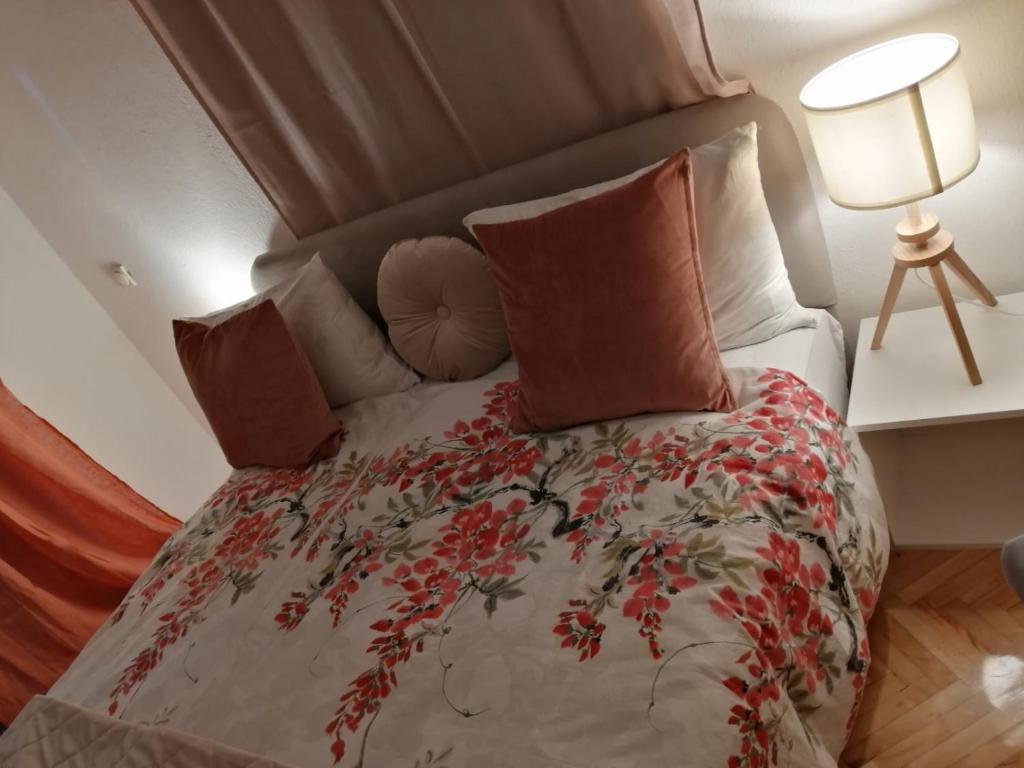 a bedroom with a bed with red flowers on it at Park 1 MARKO FREE PARKING in Vranje