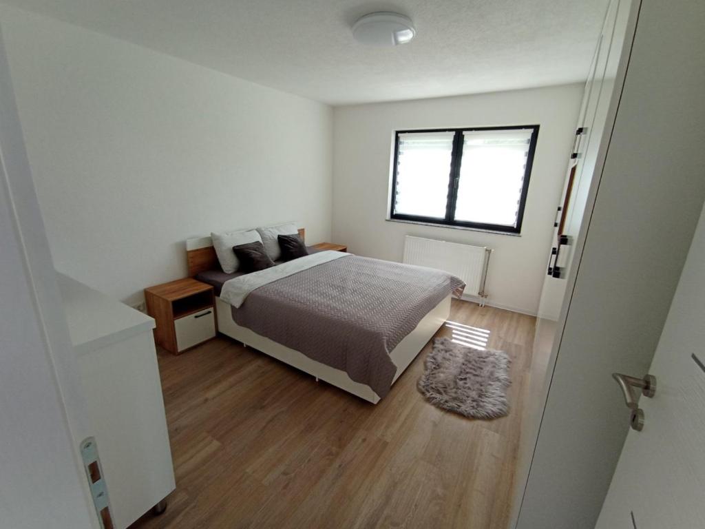 a bedroom with a bed and a window at Apartman Nina in Tuzla