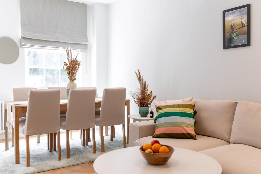 ein Wohnzimmer mit einem Sofa und einem Tisch in der Unterkunft 3 Bedroom flat with Terrace in Central London in London
