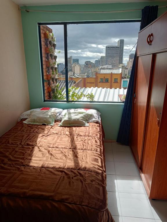 a bed in a room with a large window at Casa 2600 in Bogotá