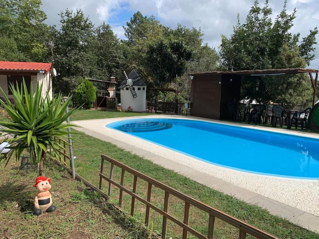 una piscina en un patio con un osito de peluche al lado en Finca con dos casas rurales, en Randufe