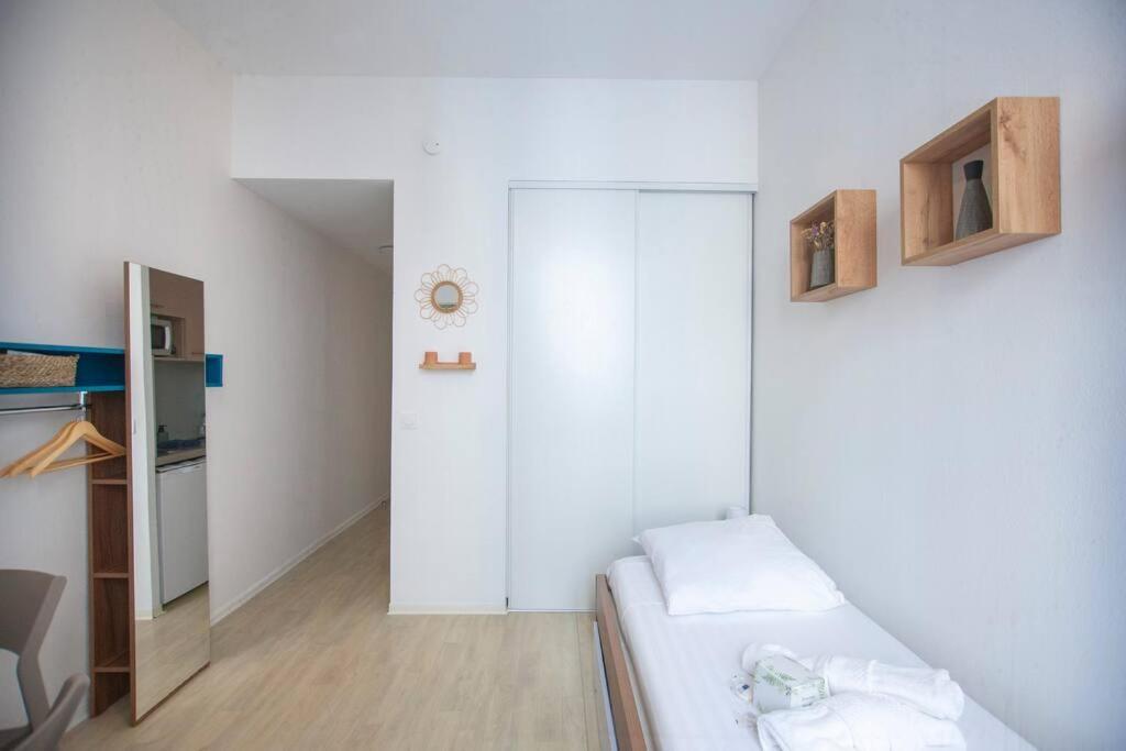 a small white room with a bed and a kitchen at SENAC - Havre citadin, La Canebière in Marseille