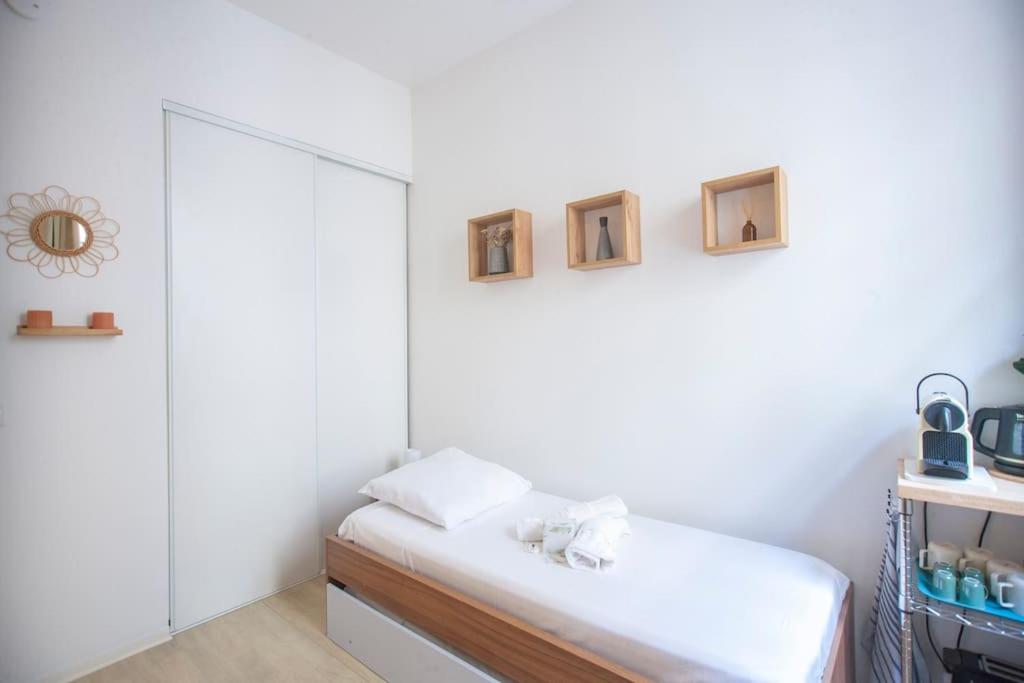 a white room with a bed and a mirror at SENAC - Havre citadin, La Canebière in Marseille