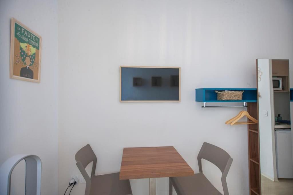 a kitchen with a table and two chairs and a tv at SENAC - Havre citadin, La Canebière in Marseille