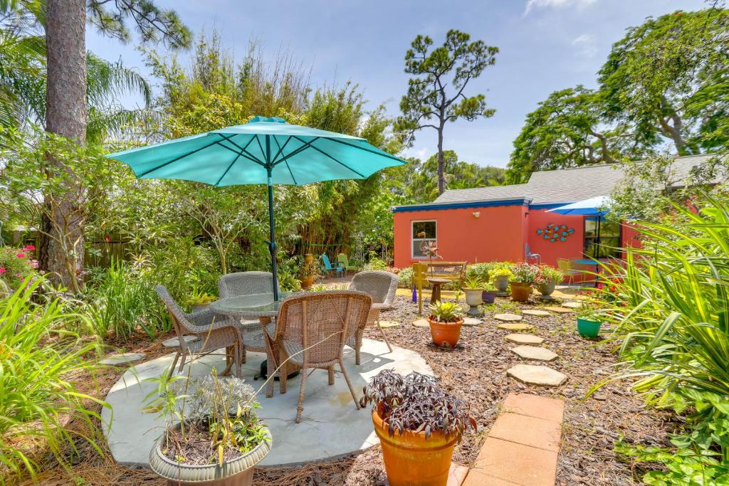 a patio with a table and chairs and an umbrella at Colorful Gulfport Home Walk to the Art District! in St. Petersburg
